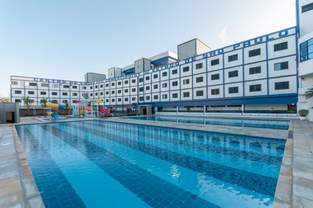 Piscina do Centro de Lazer em Praia Grande, com o prédio de apartamentos ao fundo